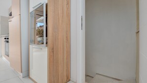 Une cuisine moderne avec des meubles en bois, une porte en verre et un plan de travail blanc.
