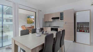 Une cuisine moderne avec un coin repas, un four encastré et un réfrigérateur.