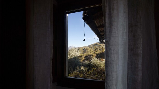 Ein Fenster mit Blick auf eine Berglandschaft.