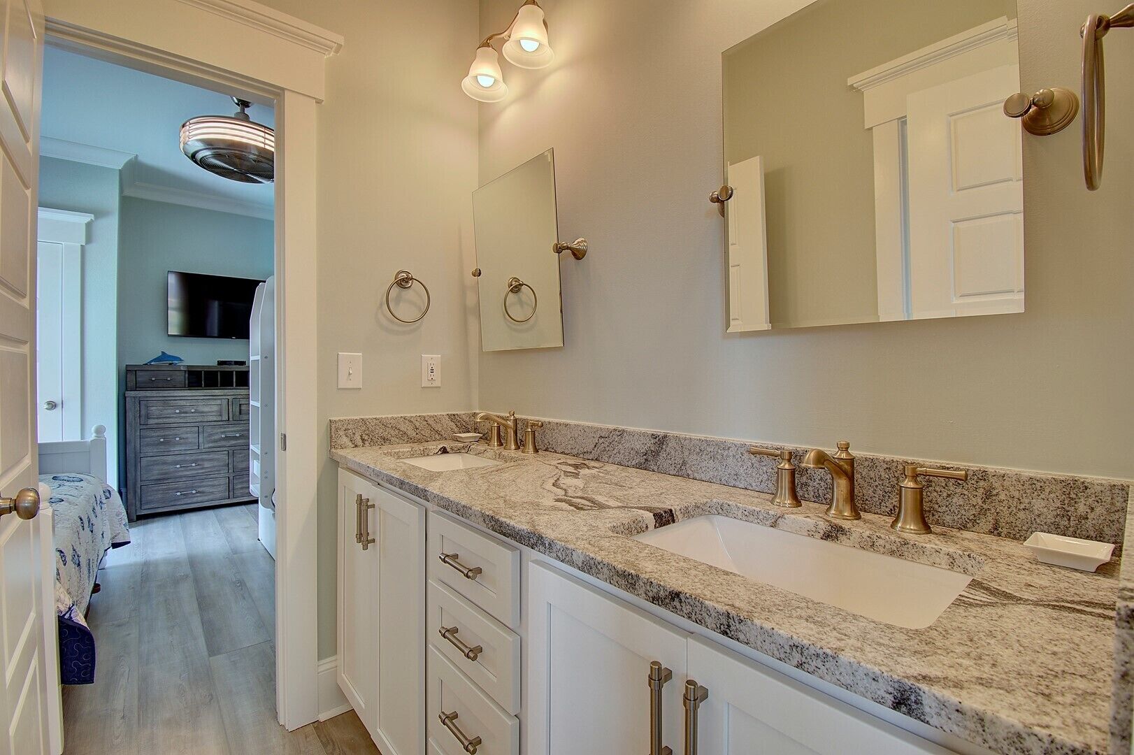 A bathroom with two sinks, a mirror, and a vanity with drawers.