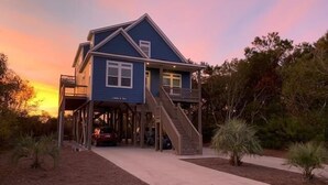 A two-story house with a balcony and a staircase leading to the upper level. - Oceanview retreat in Oak Island with 4 bedrooms, perfect for family gatherings. (Oak Island)