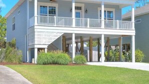 Une maison à deux étages avec un balcon, une véranda et un garage.