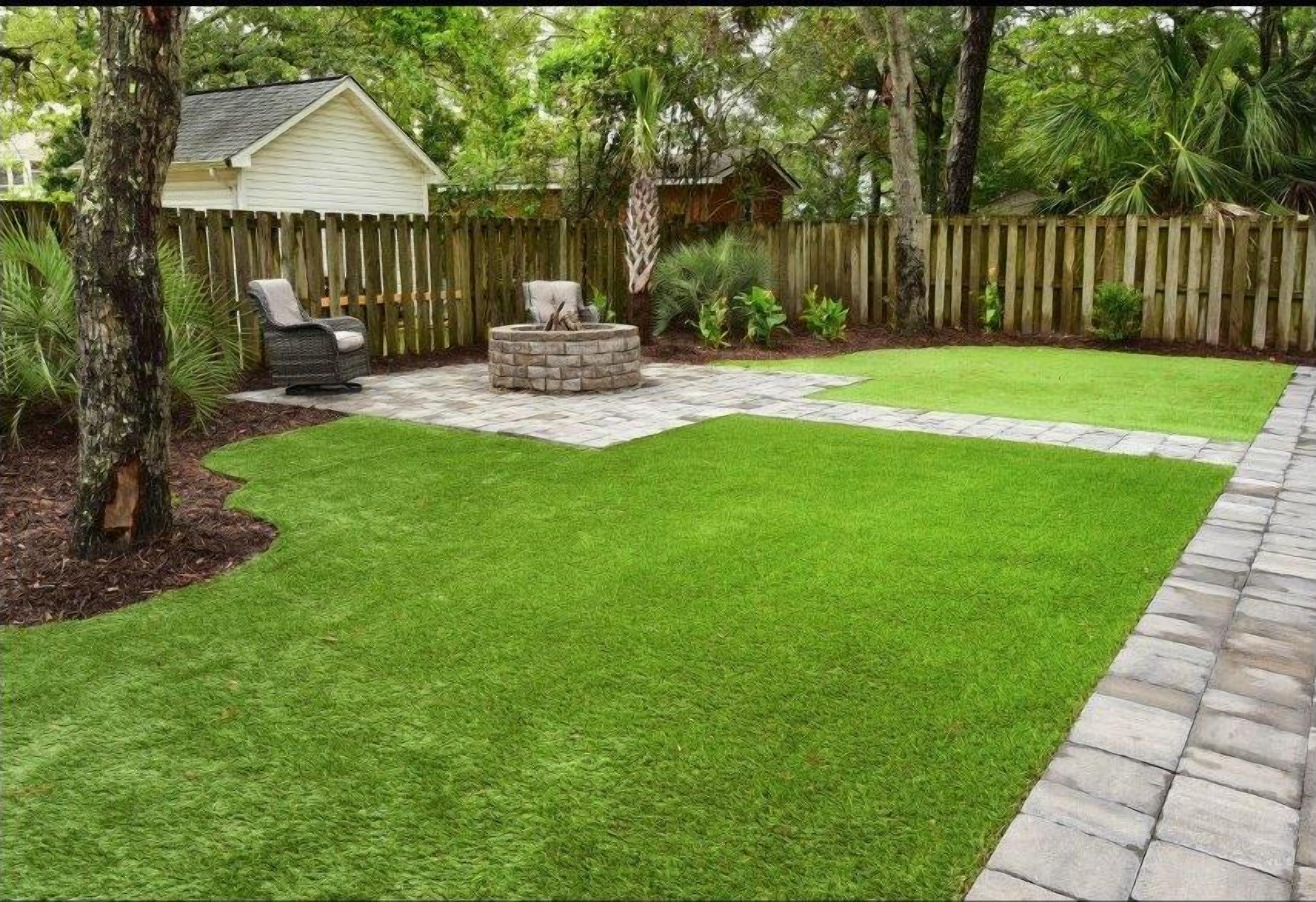A backyard with a lawn, a wooden fence, a small shed, and a stone fire pit.