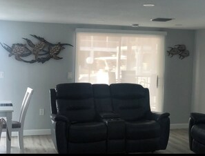 Relax in this stylish living room with a comfortable sofa, large window, and beautiful wall art.