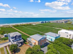 A coastal residential area with houses, a beach, and a clear sky.