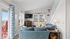 Una sala de estar con sofá, lámpara y ventana con contraventanas.