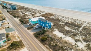 Una propiedad costera con vista al mar, una carretera y un edificio pequeño con balcón.