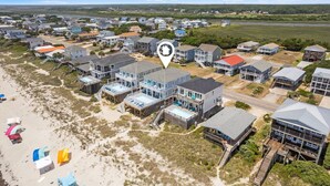 An aerial view of a coastal residential area with houses, a beach, and a water body. - Experience oceanfront luxury at Cordoba, a spacious 7-bedroom retreat in Oak Island! (Oak Island)
