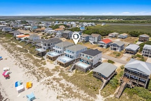 Vista aérea de una zona residencial costera con casas, una playa y una masa de agua.