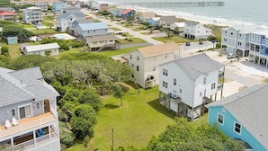 A coastal residential area with houses, a pier, and a beach. - Experience ocean views at Oak Island's 4-bedroom Kelly Dawn, perfect for 10 guests! (Oak Island)