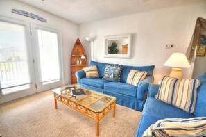 Relax in this inviting living room with a sofa, coffee table, and bookshelf.