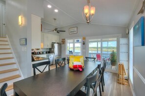 Una cocina moderna con comedor, ventilador de techo y vistas al exterior.