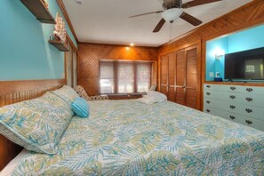Une chambre à coucher avec un lit, une armoire en bois et un téléviseur.
