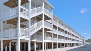 A multi-story hotel with balconies and a covered walkway.