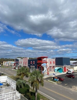 Stylish commercial area with a mix of modern and traditional architecture, set amidst palm trees.