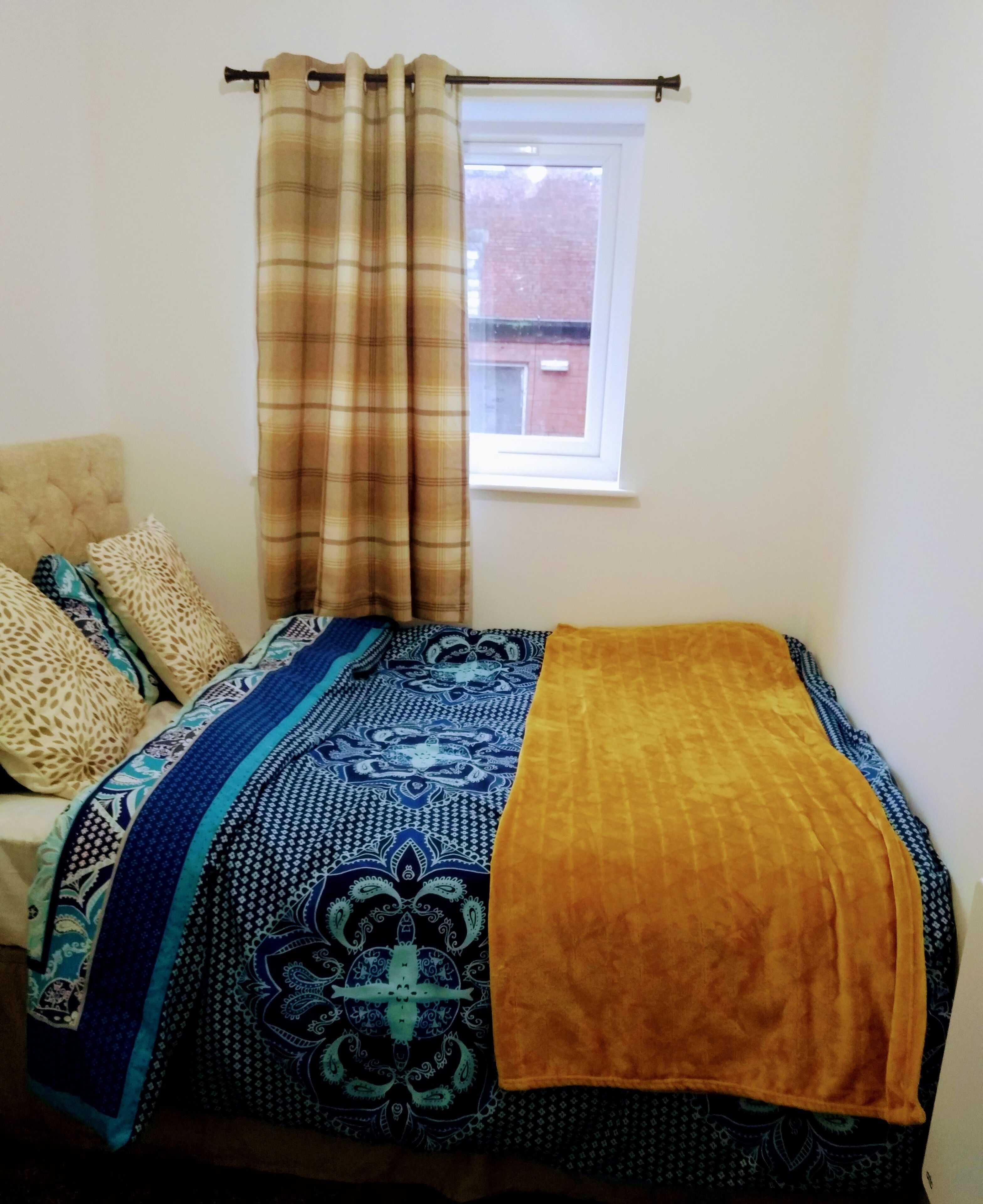 Una camera da letto con un letto, una finestra e una tenda.