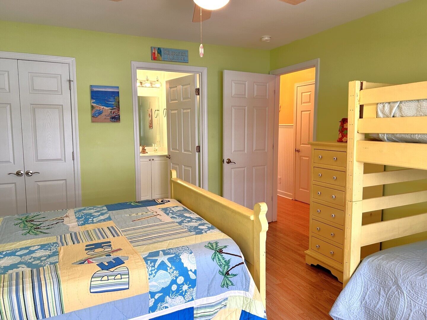 Een slaapkamer met een bed, een dressoir en een deur naar een andere kamer.
