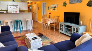 Un espacio habitable compacto con cocina, comedor y televisor.