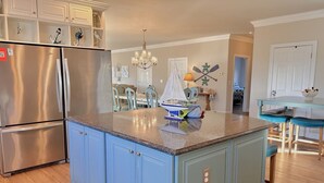 A kitchen with a central island, stainless steel appliances, and light blue cabinetry.