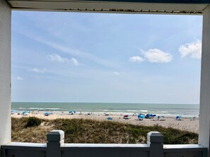 A beach view from a covered area with a clear sky.