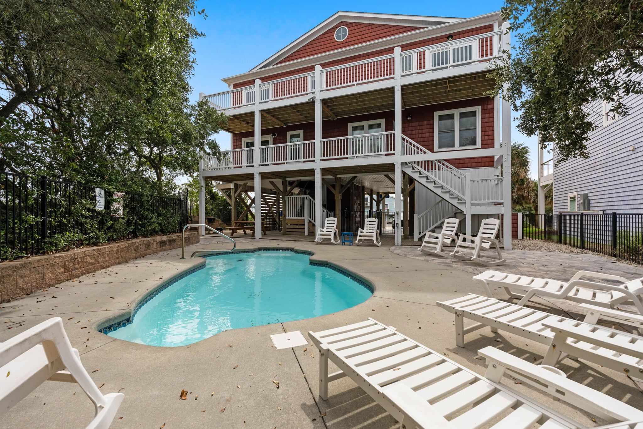 A two-story building with a pool and outdoor seating.