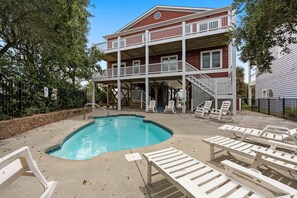 A two-story building with a pool and outdoor seating.