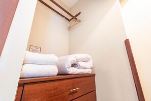 Comfortable hotel room with a wooden cabinet, coat rack, and neatly folded towels.