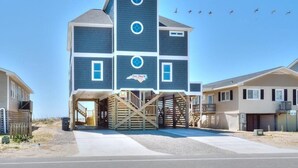 Een meerhoog gebouw met een Sea Shack bord, een overdekte ingang en een trap die naar de hogere verdiepingen leidt.