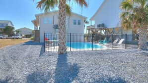 A residential property with a swimming pool, a fenced patio area, and a palm tree. - Seas the Moment: 5BR oceanview retreat in Oak Island, perfect for families! (Oak Island)