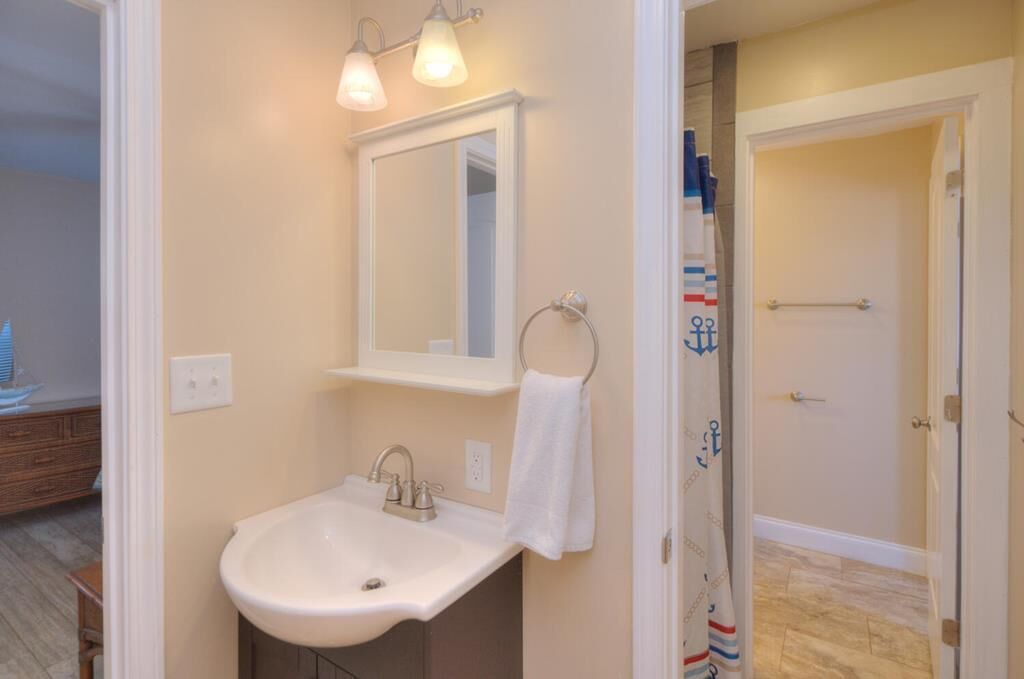 Une salle de bain équipée d’un lavabo, d’un miroir et d’un porte-serviettes.