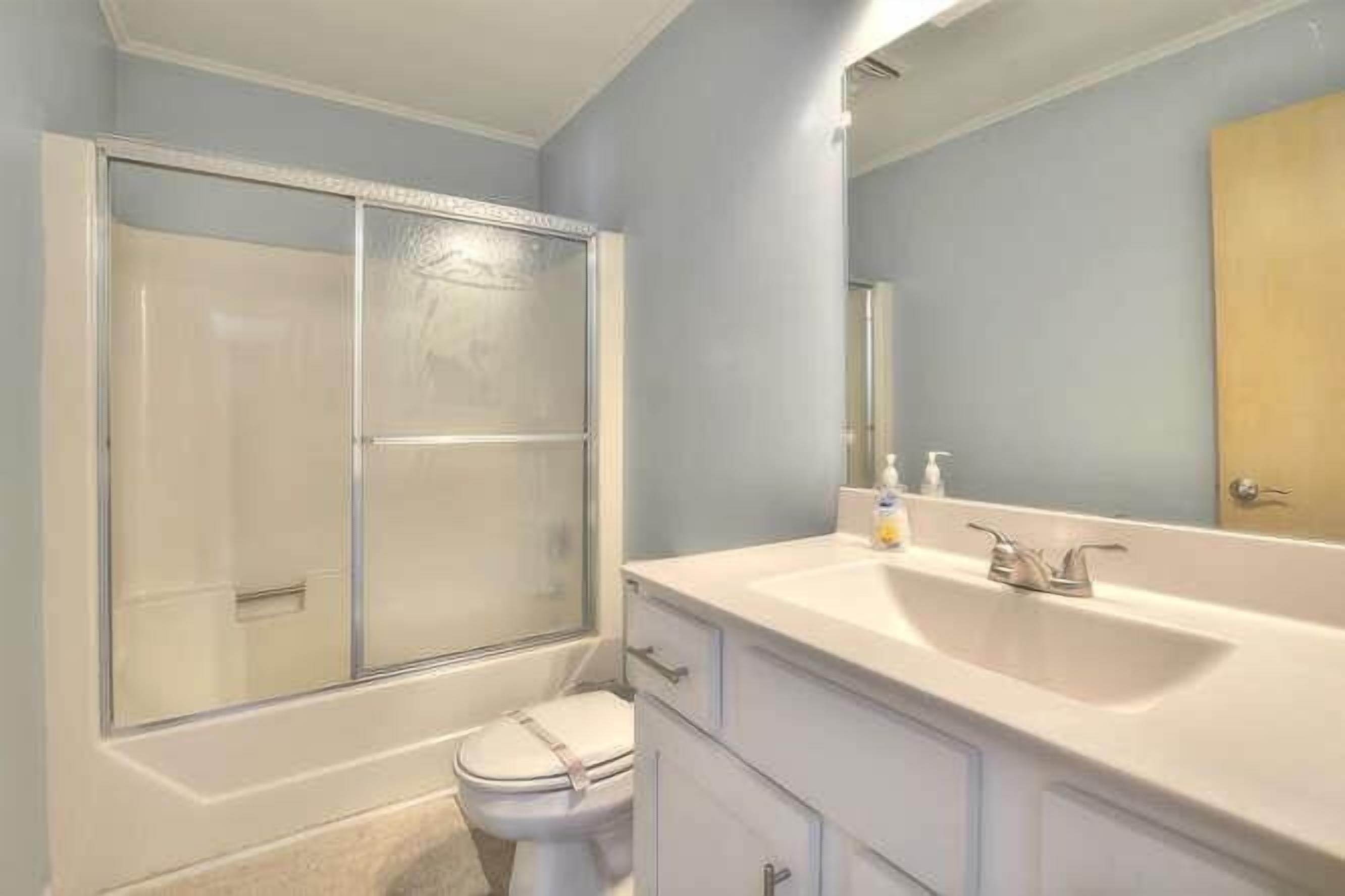 Une salle de bain équipée d’une douche, de toilettes et d’un meuble-lavabo avec un évier.