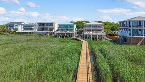 Una propietat costanera amb diversos edificis, una passera de fusta i un camp de gespa.