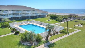 Un hôtel doté d’une piscine, offrant une vue sur la plage et comprenant un patio couvert.