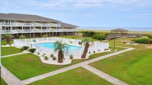 Un hôtel à plusieurs étages doté d’une piscine, d’un patio couvert et offrant une vue sur la plage.