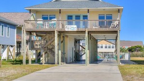 A two-story building with a balcony and a sign that reads "Jolly Rogers." - The Jolly Rogers: Oceanview house in Oak Island with private pool and spacious layout. (Oak Island)