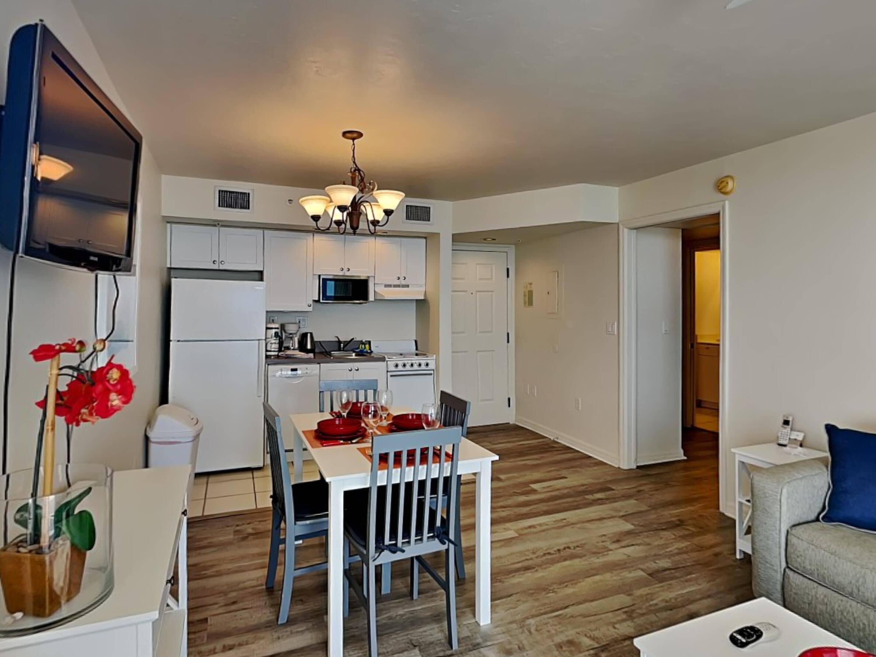 Um espaço compacto com área de refeições, kitchenette e um pequeno espaço para sentar.