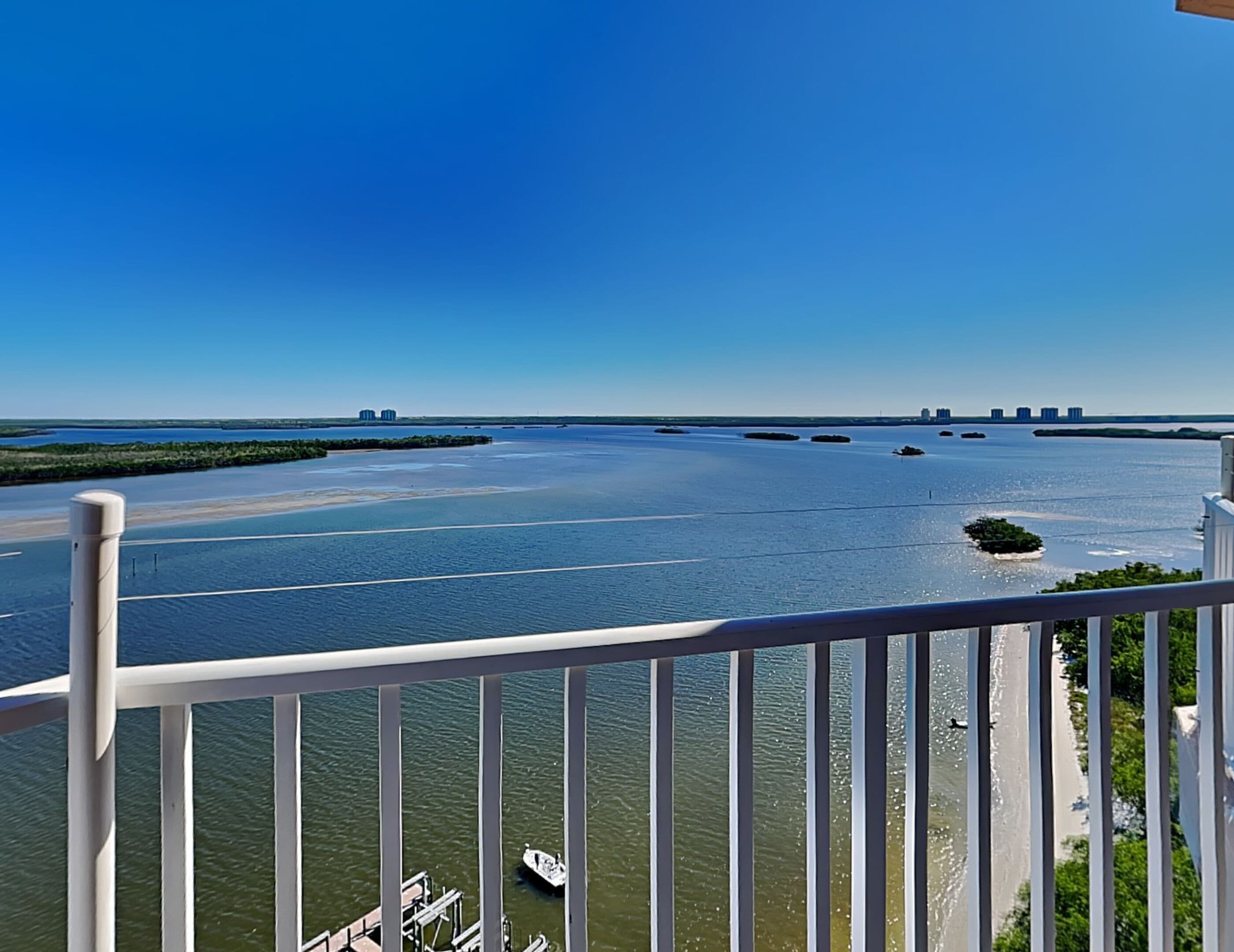A view of a river with boats, a dock, and buildings in the distance.