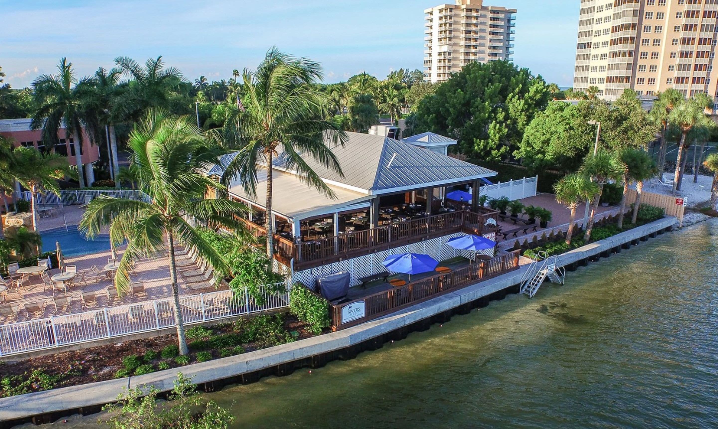 Ein Restaurant am Wasser mit Außenbereich, einer überdachten Terrasse und Blick auf das Wasser.