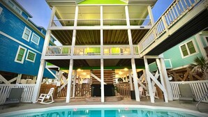 A two-story building with a pool in front. - Discover Zion in Oak Island: an oceanfront dream with 5 bedrooms for 12 guests! (Oak Island)