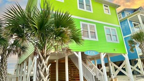 A two-story house with a porch, a staircase, and a sign that reads 'ZION'. - Discover Zion in Oak Island: an oceanfront dream with 5 bedrooms for 12 guests! (Oak Island)