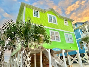 A two-story house with a porch, a staircase, and a sign that reads 'ZION'. - Discover Zion in Oak Island: an oceanfront dream with 5 bedrooms for 12 guests! (Oak Island)