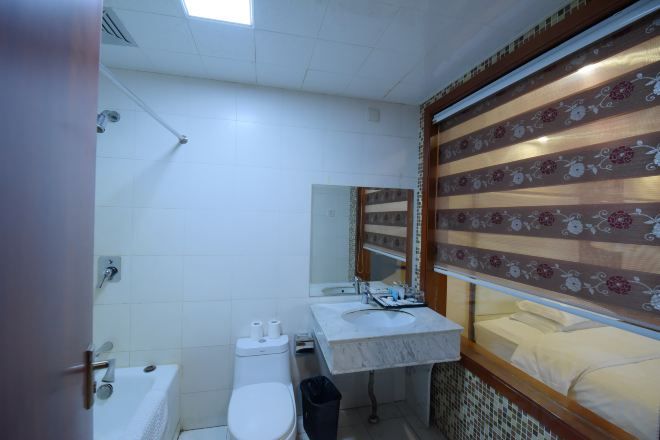 A bathroom with a toilet, sink, and shower.