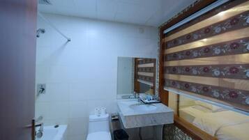 A bathroom with a toilet, sink, and shower.