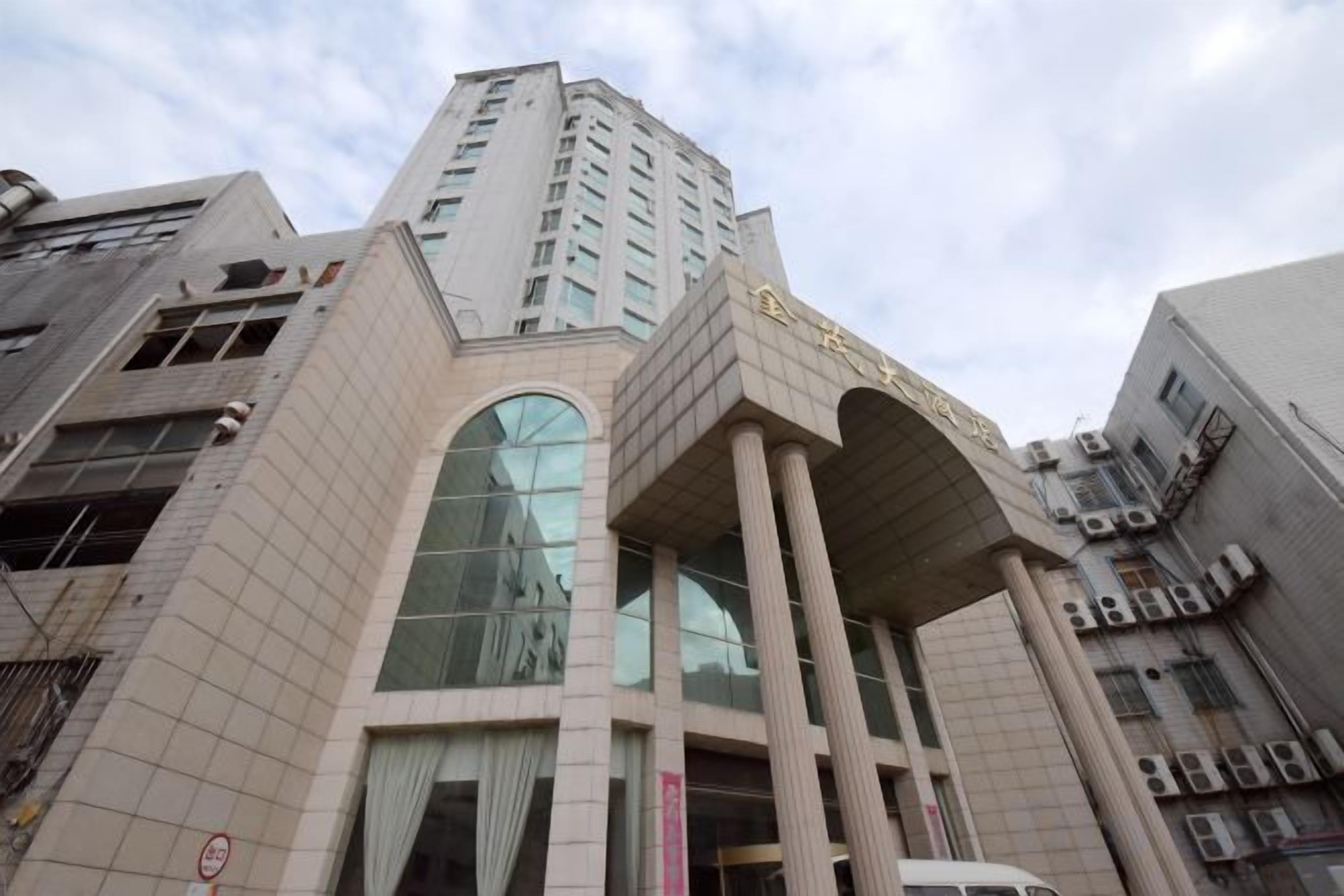 Un edificio de varios pisos con una entrada destacada, ventanas grandes y un diseño arquitectónico moderno.