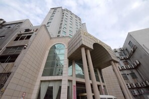 A multi-story building with a prominent entrance, large windows, and a modern architectural design.