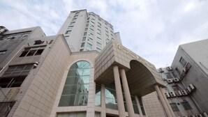 A multi-story building with a prominent entrance featuring large glass windows and a central archway. - Nishi Kingmau Hotel (Changzhou)