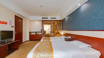 A hotel room with a large bed, a television on a stand, and a mirror on the wall.