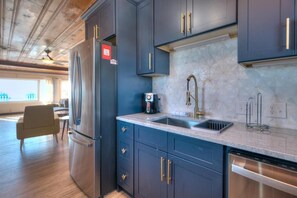 A modern kitchen with dark cabinets, stainless steel appliances, and a marble backsplash. - Enjoy oceanfront views at 'These Are The Days' in Oak Island, NC. Perfect for 6! (Oak Island)