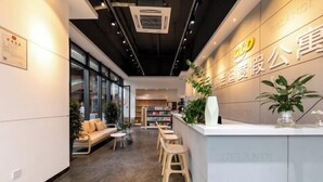 Ein modernes Interieur mit einer Rezeption, einer Sitzecke und Bücherregalen.