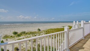 A beach view with a white fence and a wooden deck. - Experience oceanfront luxury at AfterDune Delight, Oak Island's ideal getaway for 20 guests. (Oak Island)